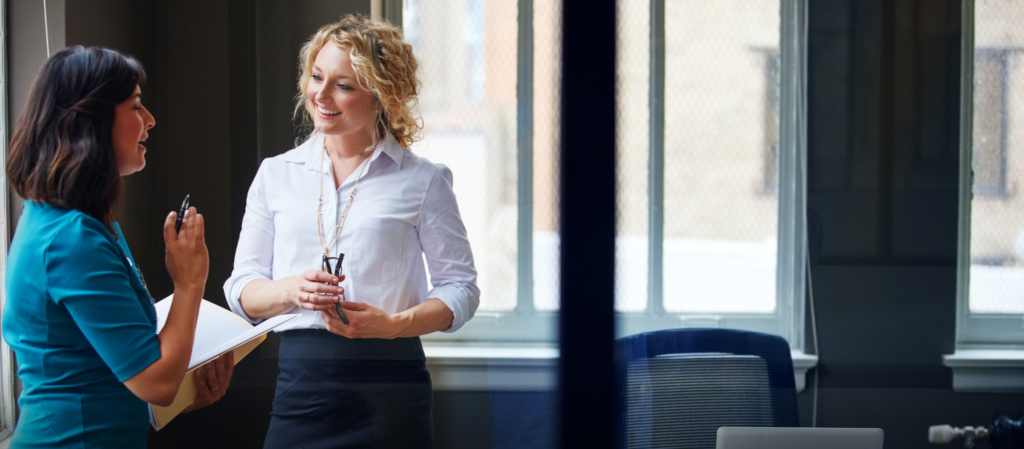 afbeelding van twee vrouwen die met elkaar overleggen