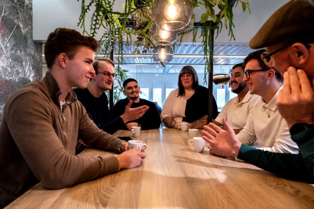 Het hele Tolkie-team overlegt aan de lunchtafel